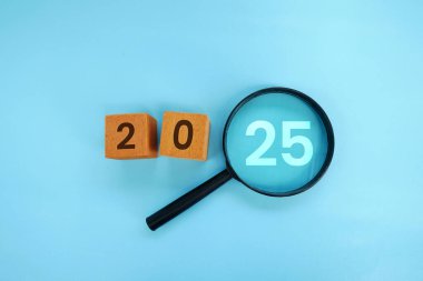 Büyüteç ve hedef 2025. Yeni yıl kavramı 2025, başarının başlangıcı, meydan okuma veya kariyer yolu, değişim, planlama, hedefler, zorluklar ve yeni yıl kararları.