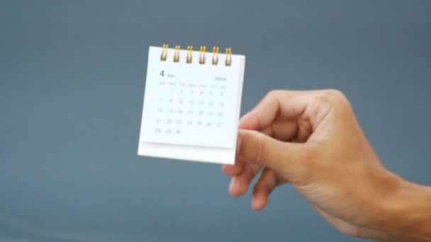 ハンド保持月カレンダー 2024 灰色の背景に — ストック動画