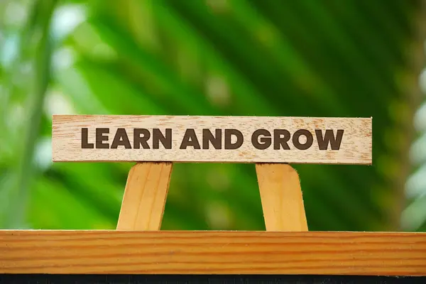 Learn and grow. Word concept Learn and grow on wooden blocks with nature background
