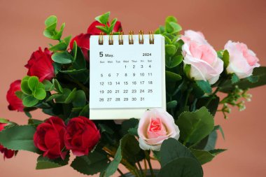 Mayıs 2024 - Yumuşak bir arkaplan, zaman ve iş konsepti üzerine küçük bir masaüstü takviminin kapatılması