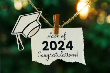  2024 sınıfı, bokeh arkaplanlı ipe asılı bir not kağıdı üzerinde.