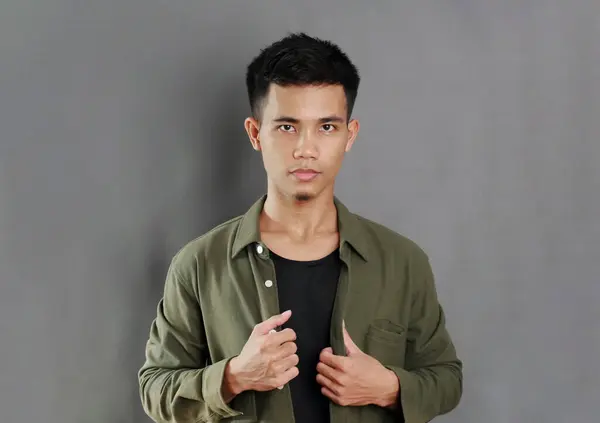 stock image Portrait of handsome Asian man in fashionable casual suit, his hands holding his shirt, confident and positive