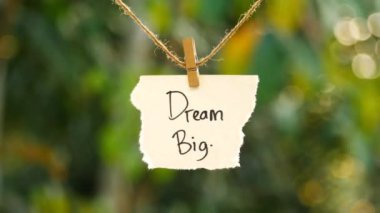 Büyük düşün - Yırtık not kağıdıyla Büyük düşün Bir iple sallan ve sallan, doğa arka planda batıyor