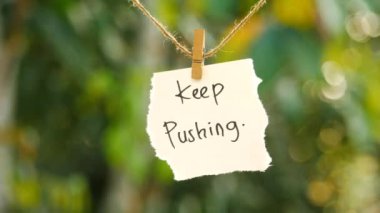 İpte asılı duran ve sallanan yırtık kağıtlara yazı yazmaya devam et. bokeh arkaplanı