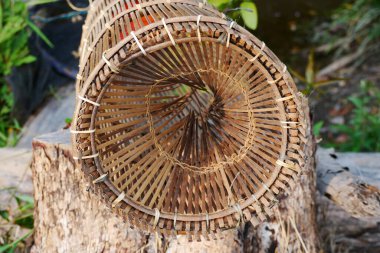 Traditional Indonesian fish traps made from woven bamboo form trap chimneys clipart