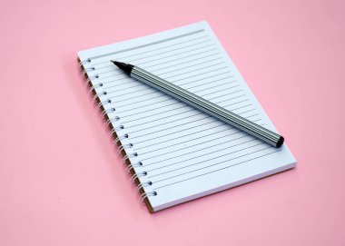 Boş beyaz kağıt ve pembe arka planda bir kalem.