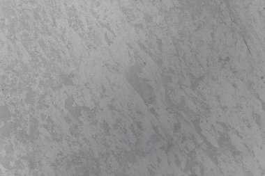 Doğal lekeleri ve dokusu olan pürüzlü gri beton yüzey, arka plan, inşaat temaları veya mimari modeller için idealdir..