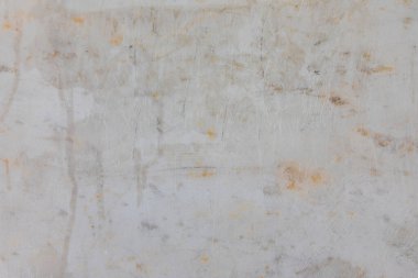 Üzerinde çizikler, lekeler ve yıpranmış dokular olan eskimiş beyaz bir yüzeye yakın plan, grunge tasarımı veya endüstriyel temalar için ideal..