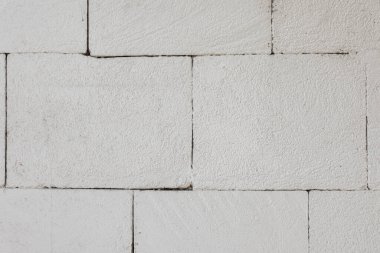 Kabataslak desenli yüzeyi ve görünür dikişleri olan beyaz boyanmış tuğla bir duvara yakın plan veya mimari modeller için ideal..