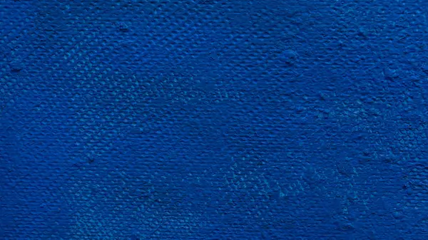 Koyu mavi boyalı, ince fırça izleri ve yüzeysel kusurları gösteren desenli bir duvara yakın plan.