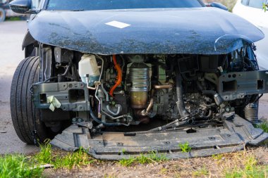 Ön tamponu sökülmüş, karmaşık motor bileşenleri, kablolar ve iç sistemleri ortaya çıkaran modern bir arabanın yakın çekimi..