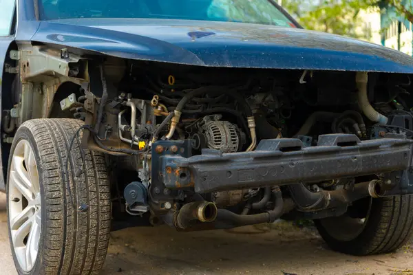 Hasarlı bir aracın ön görüntüsü. Tamponu eksik ve motor parçaları korunmasız..