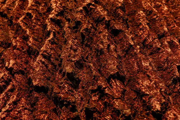 Engebeli, kırmızı-kahverengi ağaç kabuğunun yakın çekimi derin oyuklar ve doğal doku gösterir, arka plan veya doğa temalı tasarımlar için idealdir..