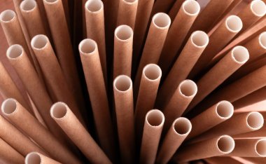 Kahverengi biyo-çözünebilir kağıt kamışların makro görüntüsü radyal bir desen içinde ayakta duruyor, eko-dost ve sürdürülebilir yaşam tarzı seçimlerini vurguluyor.