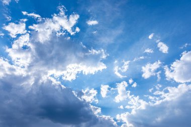 Yumuşak, beyaz kümülüs bulutlarıyla dolu canlı mavi gökyüzü, çeşitli yaratıcı kullanım alanları için parlak ve canlandırıcı bir doğal zemin oluşturuyor..