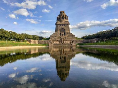 Leipzig Almanya 'sında Milletler Muharebesi Anıtı' nın çarpıcı manzarası. Etkileyici bir savaş anıtı öndeki sakin sularda önemli bir tarihi ve mimari dönüm noktasıdır.