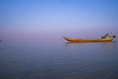 Landscape View of a small cargo ship against a blue sky on the  Padma river Bangladesh