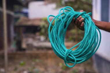 Green rope in the hand of a man. Close-up image.