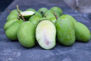 Yakından bakınca beton zeminde dilimlenmiş mangolu taze çiğ mango. Turşu malzemesi