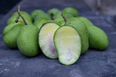 Yakından bakınca beton zeminde dilimlenmiş mangolu taze çiğ mango. Turşu malzemesi