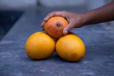 Masada elinde mango meyvesi var. Seçici odak