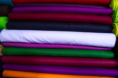 Artistic variety shade tone colors Textile Fabrics stacked on retail Shop Shelf to sale