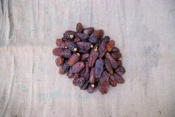 Some delicious Date fruits on the brown jute fiber fabric to eat during Ramadan Karim fasting