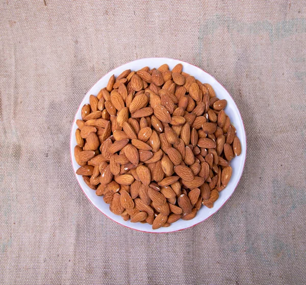 褐色面料上的A碗杏仁的头像 — 图库照片