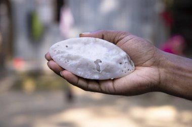 El ele tutuşan geleneksel el yapımı Chitoi pitha.
