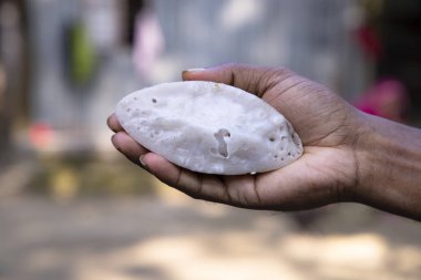 El ele tutuşan geleneksel el yapımı Chitoi pitha.