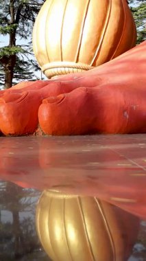 Lord Hanumanlar 'ın yakından görünüşü. Devasa kırmızı ayaklı heykel, mola ile süslenmiş.