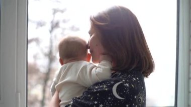 Anne yeni doğmuş bebeğini kucağında tutuyor. Yeni doğan anne ve bebeğin ev portresi. Birlikte eğleniyoruz.