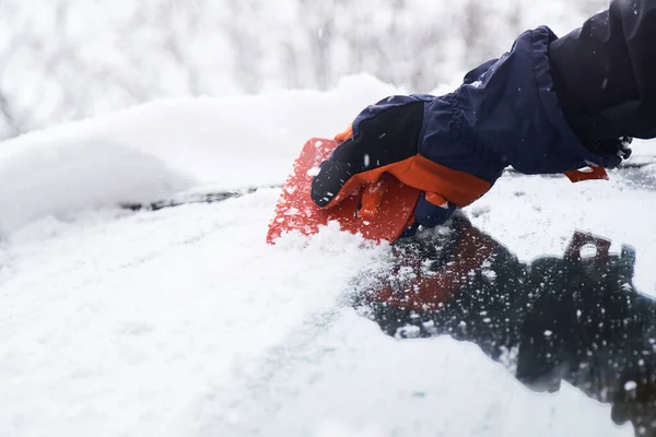 男は雪の後に車を掃除する フロントガラスからの雪のクリーニング 氷のスクレーピング 冬の車の窓のクリーニング — ストック写真