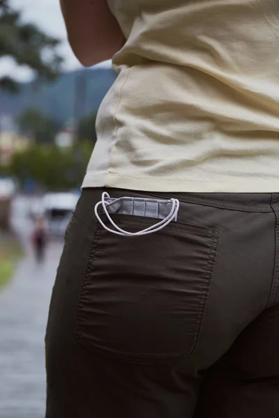 Medical face mask in back pocket. Concept for the tourism during pandemic