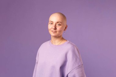 Kanserden muzdarip genç kadın gülüşü gelecekteki iyileşme hakkında olumlu düşünüyor. Milenyum dişisi, kafası kazınmış.