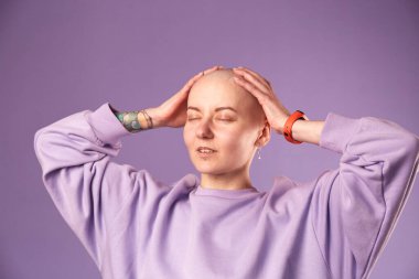 Kanserden muzdarip genç kadın gülüşü gelecekteki iyileşme hakkında olumlu düşünüyor. Milenyum dişisi, kafası kazınmış.