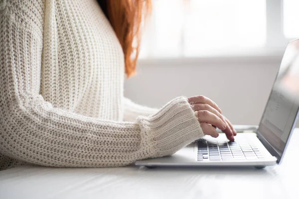 Female hands using laptop keyboard closeup. Home office concept