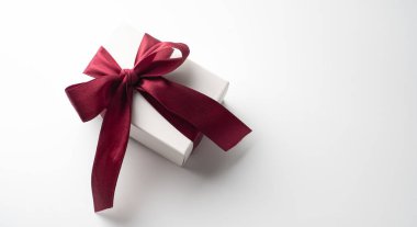 White gift box with red bow on white background with red hearts. Holiday banner. Top view. Happy Valentines Day