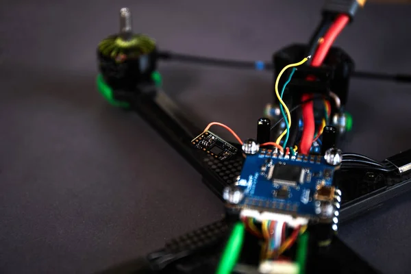 stock image Close up of man's hands assembling a drone from parts, using tools, Preparing high speed racing quadcopter for flight. Repair drone before training process.