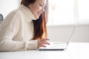 Beyaz kadın görüntülü arama yapıyor. Modern ofiste kızıl saçlı kadın.