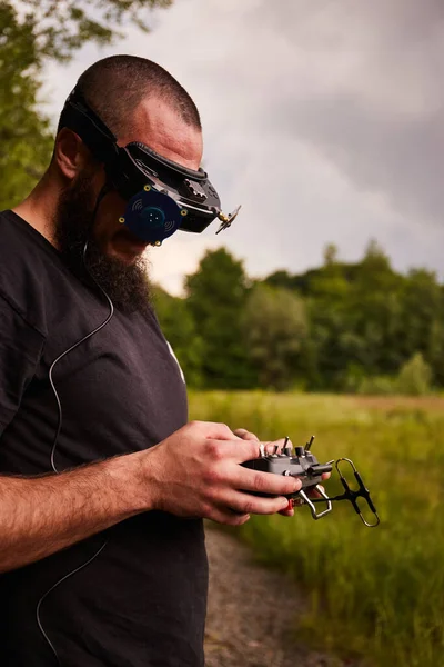 Man drone pilot with fpv drone.  Virtual reality glasses for fly his high-speed racing drone.