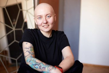 Kanserden muzdarip genç kadın gülüşü gelecekteki iyileşme hakkında olumlu düşünüyor. Milenyum dişisi, kafası kazınmış.