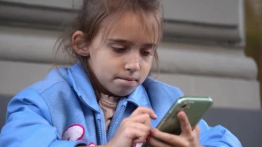 Akıllı telefon kullanan kız. oyun oynamak ya da bilgi aramak. Çocuk ve aygıt.