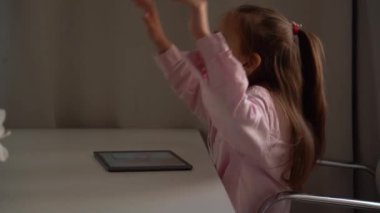 Tablet kullanan üzgün kız. Yoğun bir şekilde bir alete odaklanmış. Beyaz liseli kız Parlak Oturma Odasında Gün Boyunca Tabletle Nişanlı