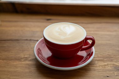 Tahta Masa üzerinde kırmızı kahve fincanı.