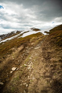 Gündüz vakti Bulutlu Gökyüzü ile Karlı Dağ Sırası. Bahar boyunca Borzhava çiftliği. Karpat Dağları, Ukrayna