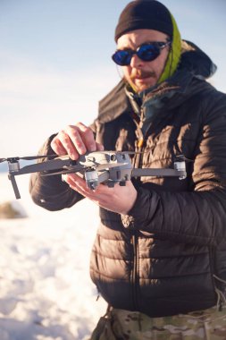 Adam Karlı Manzara 'da İnsansız Hava Aracı' nı Uçuşa Hazırlıyor. Karpat Dağları, Ukrayna 'da kış turistik gezileri