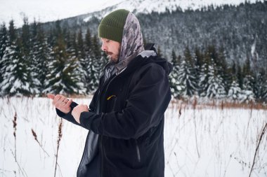 Dağcı adam, kışın dağlarda karlı orman manzarasında. Karpat Dağları, Ukrayna