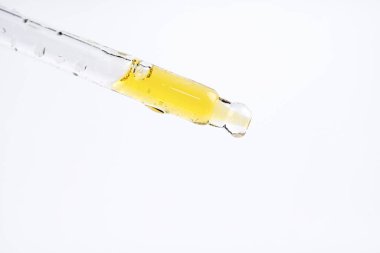 Kozmetik veya temel yağın makro fotoğrafı, cam damlacıktan dökülen serum.