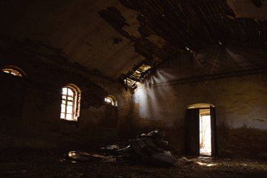 Harap olmuş bir kilise binasının içi. Işık kuyuları, enkaz ve duvarları aydınlatıyor.